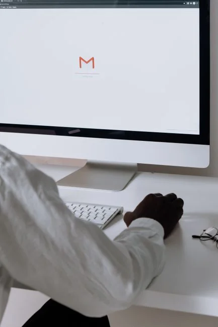 A woman examining a brand strategy document on a clipboard next to a laptop in an office setting.